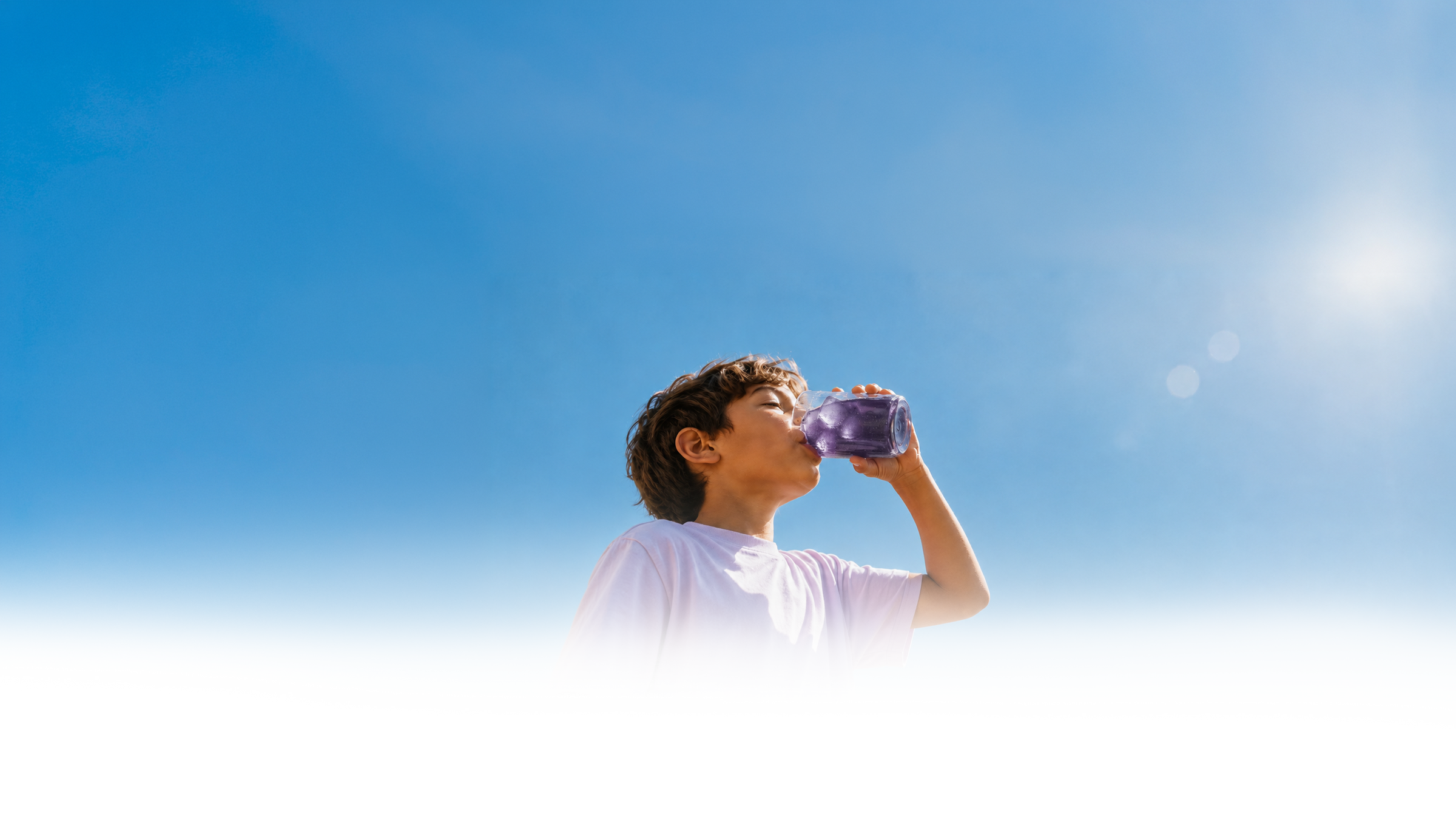 A boy drinking purple FizzyFocus outdoors under a blue sky